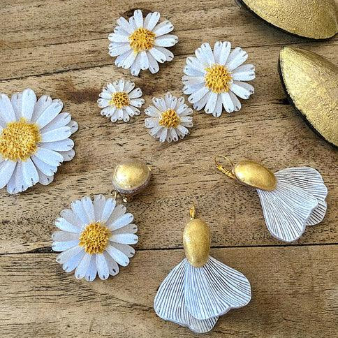 Bijoux blancs et dorés sur bois