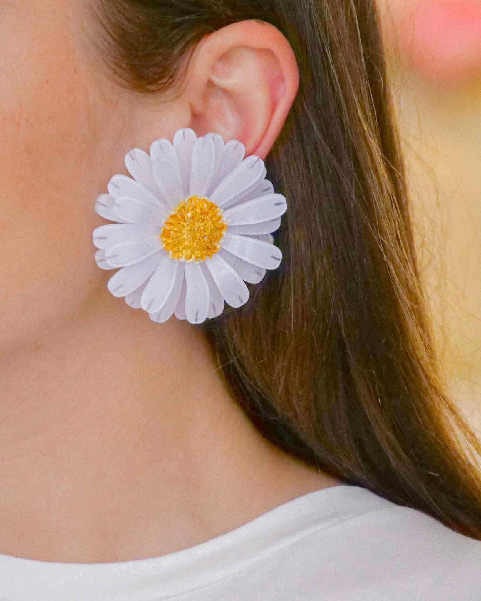 all-groups Femme portant des boucles d'oreilles marguerite