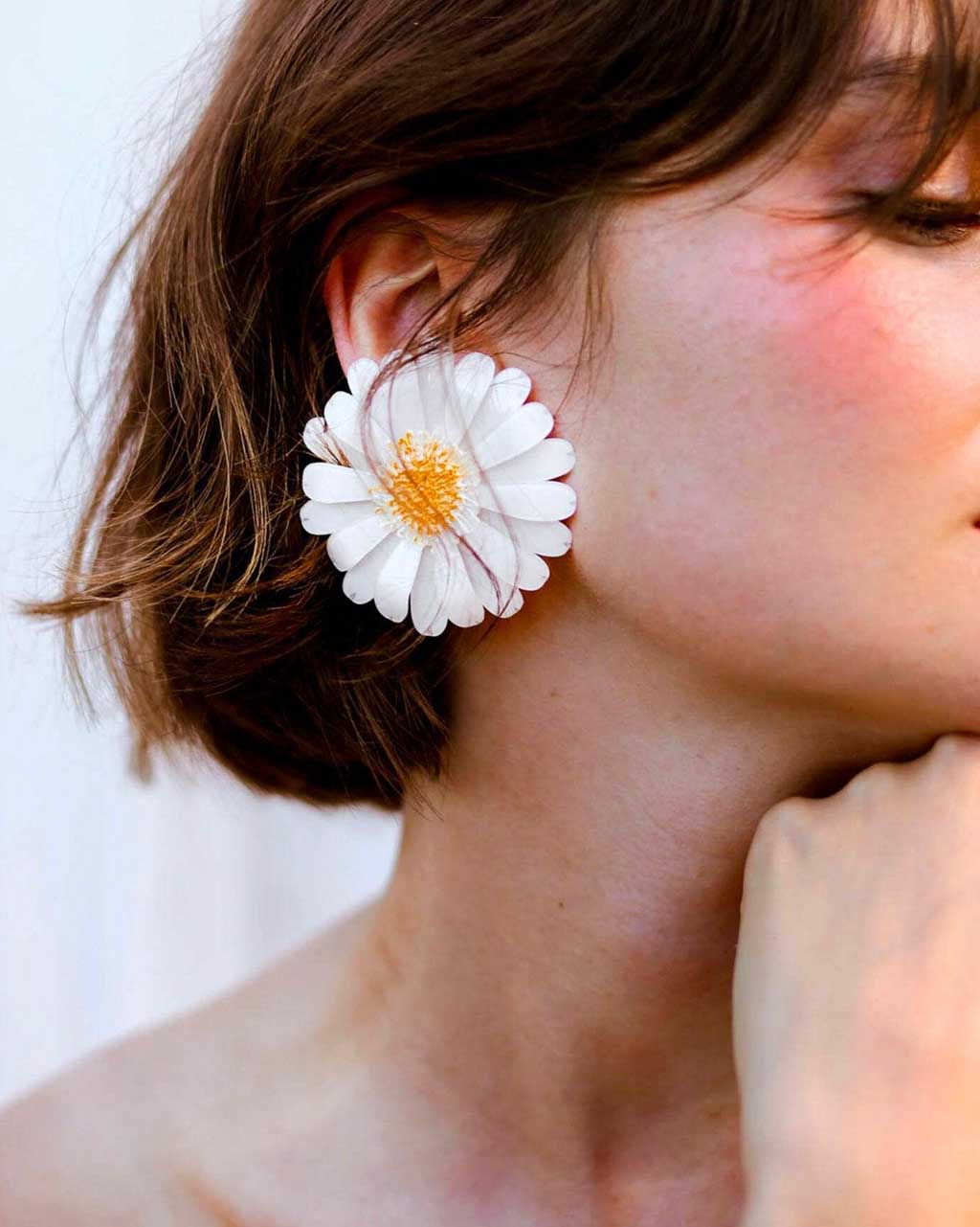 all-groups Femme portant des grandes boucles d'oreilles marguerite