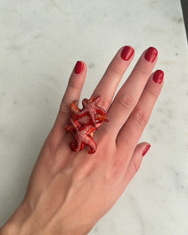 all-groups main portant une bague ariel