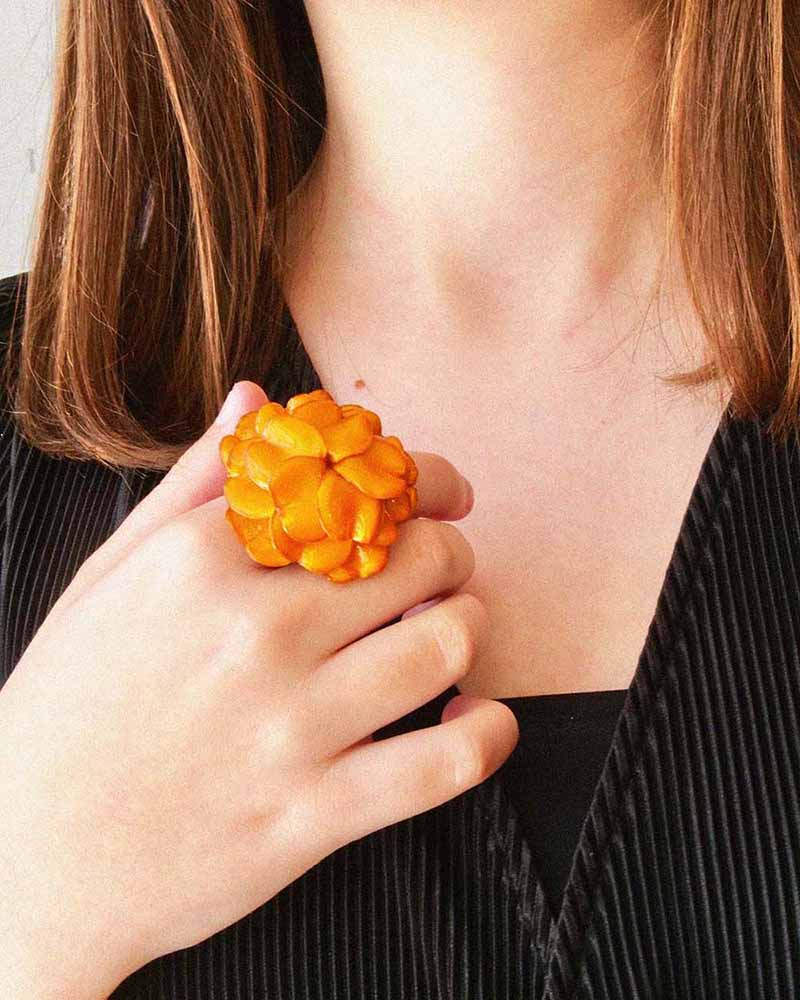 All-groups Femme portant une bague fleur orange
