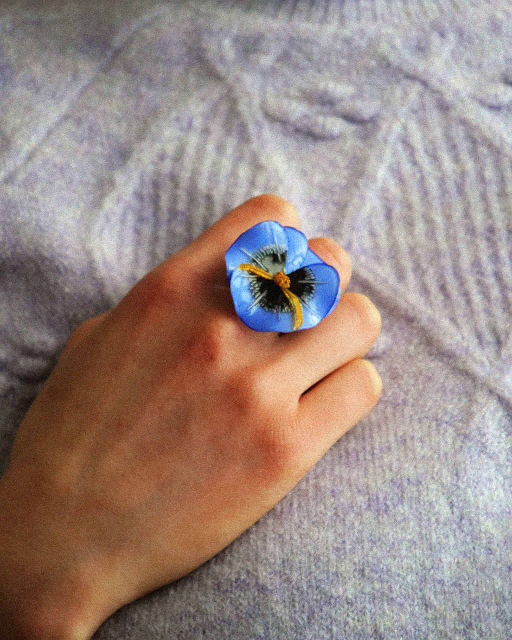 all-groups femme portant un pull lavande et une bague bleue