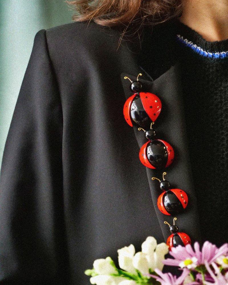 Femme portant une parure de broches bijoux fantaisie coccinelles