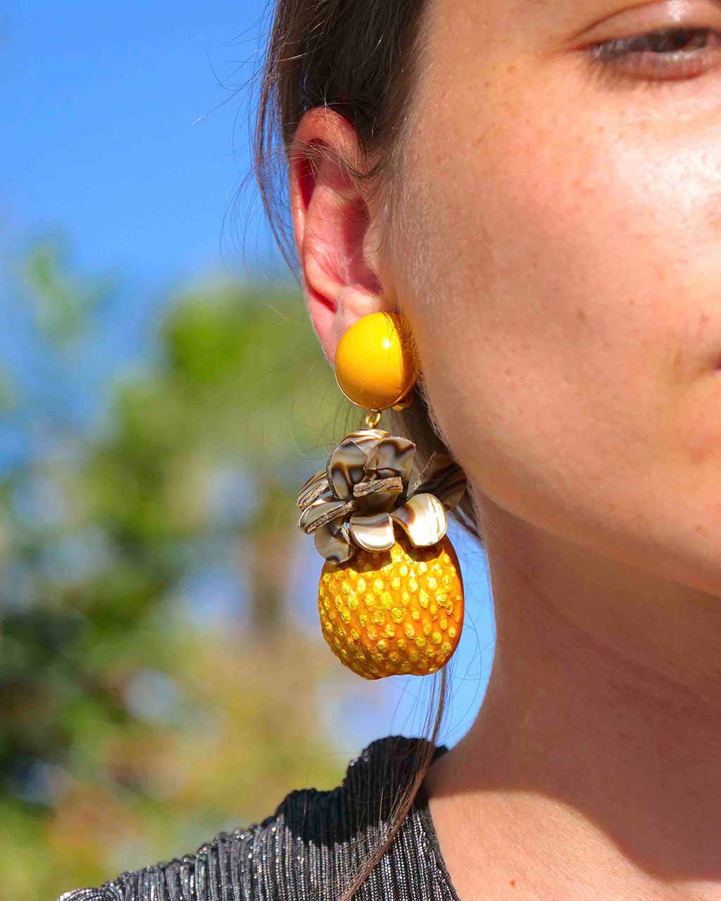 Femme portant des boucles d'oreilles ananas de notre bijouterie fantaisie