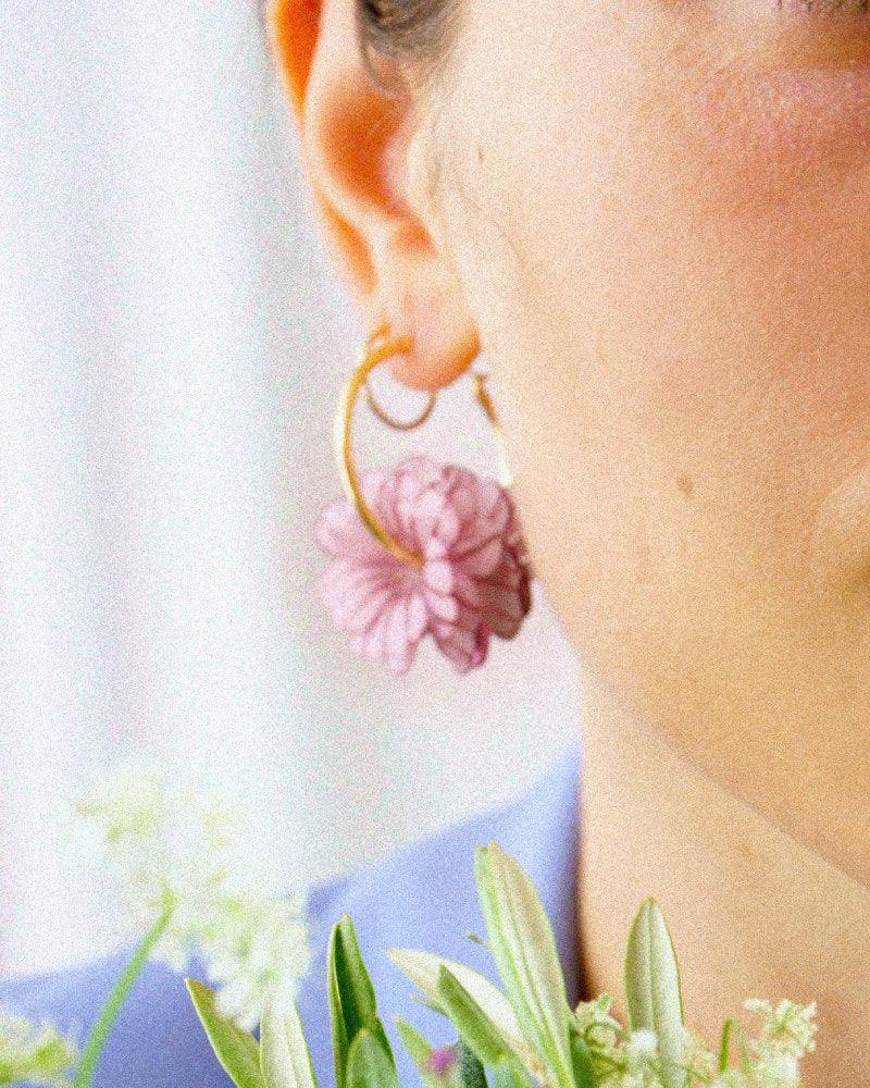 Femme portant des charms sur ses créoles or