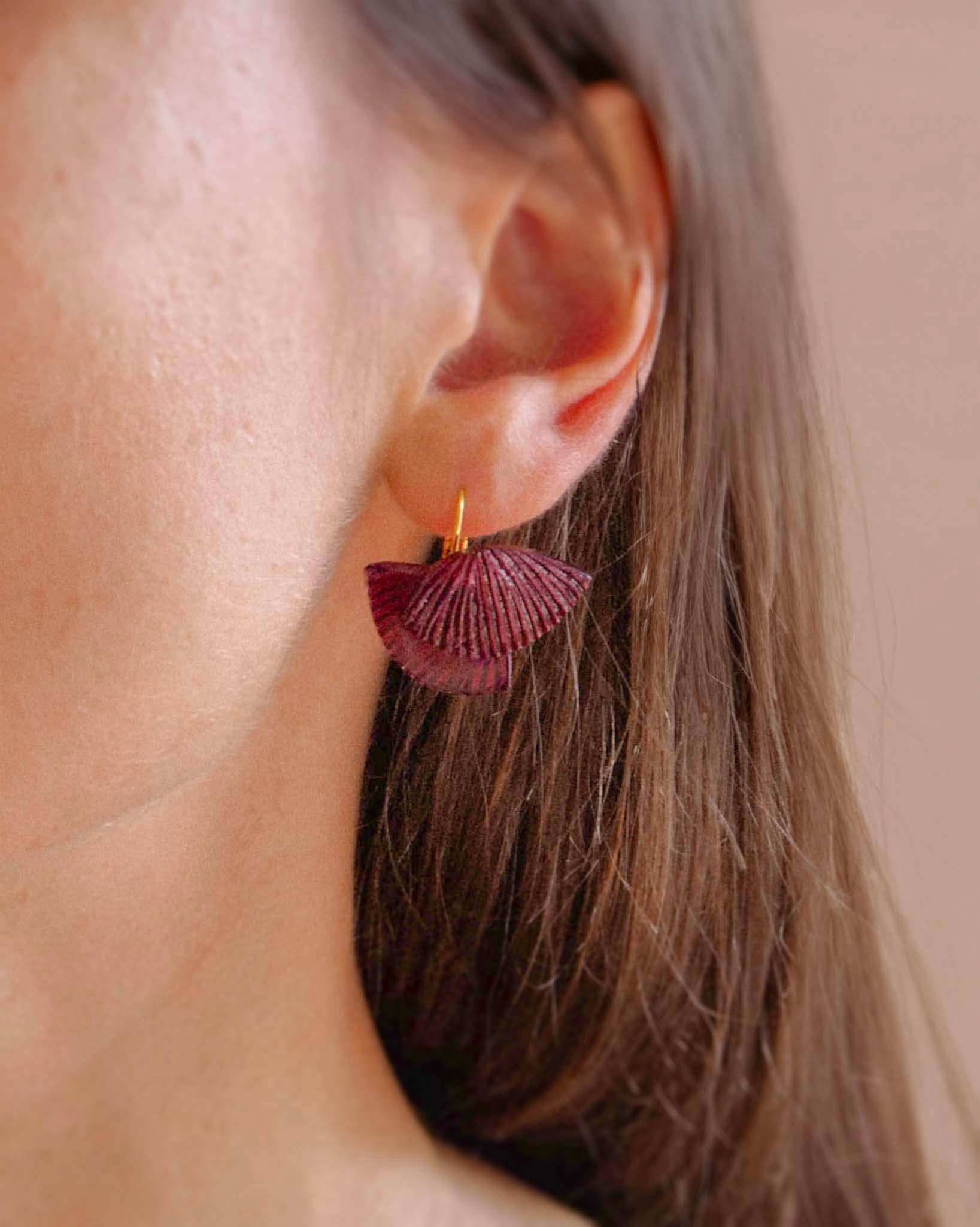 all-groups Femme portant des minis boucles d'oreilles fantaisie colorées