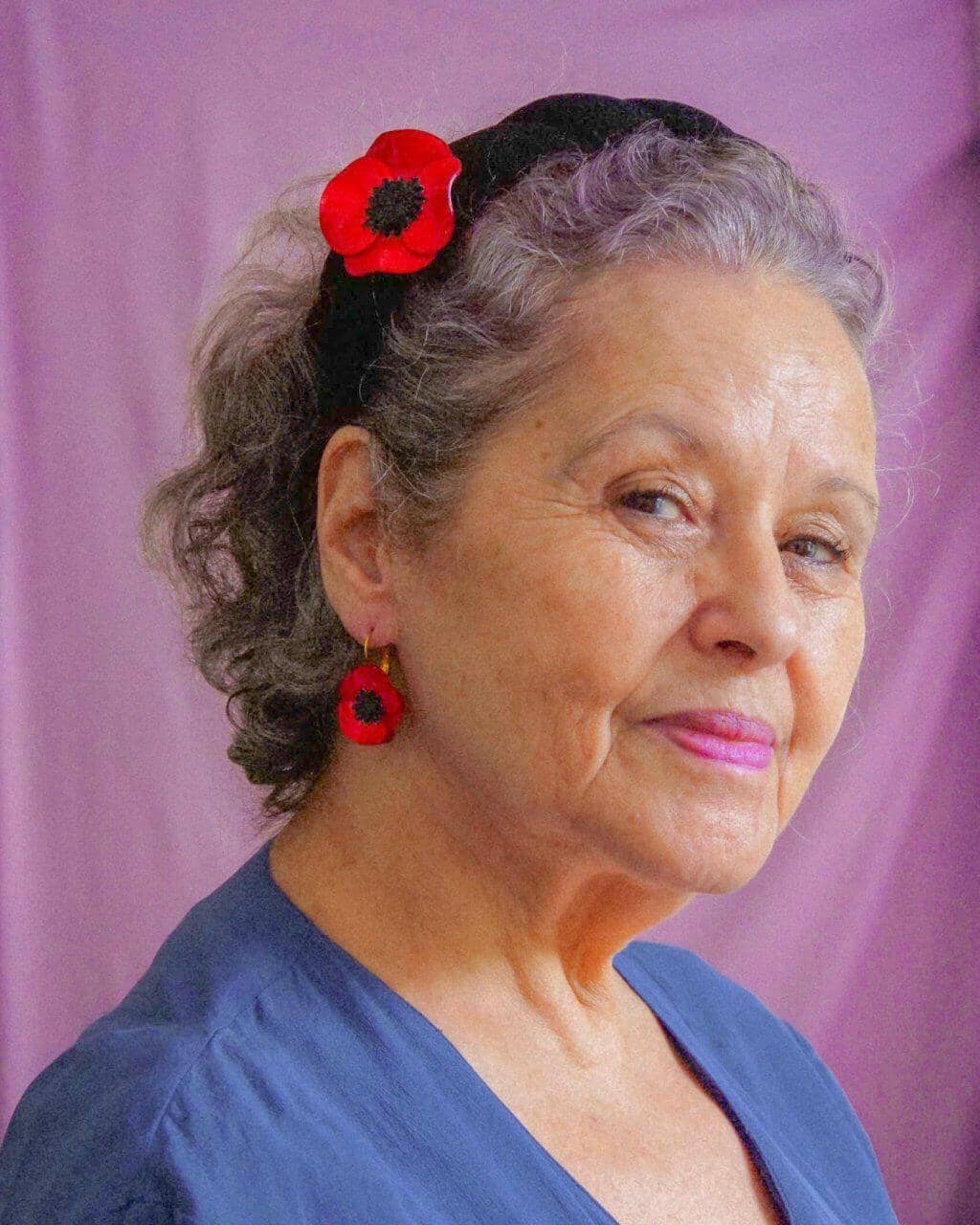 Grand mère portant une boucle d'oreille originale fleurie rouge all-groups