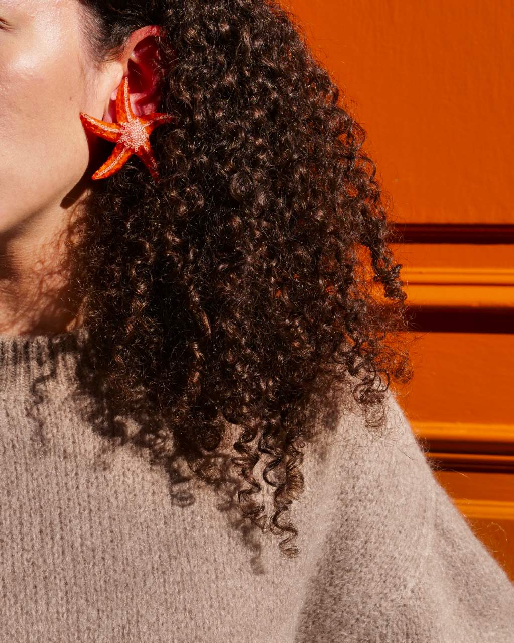 all-groups boucle d'oreille artisanale orange portée par une femme