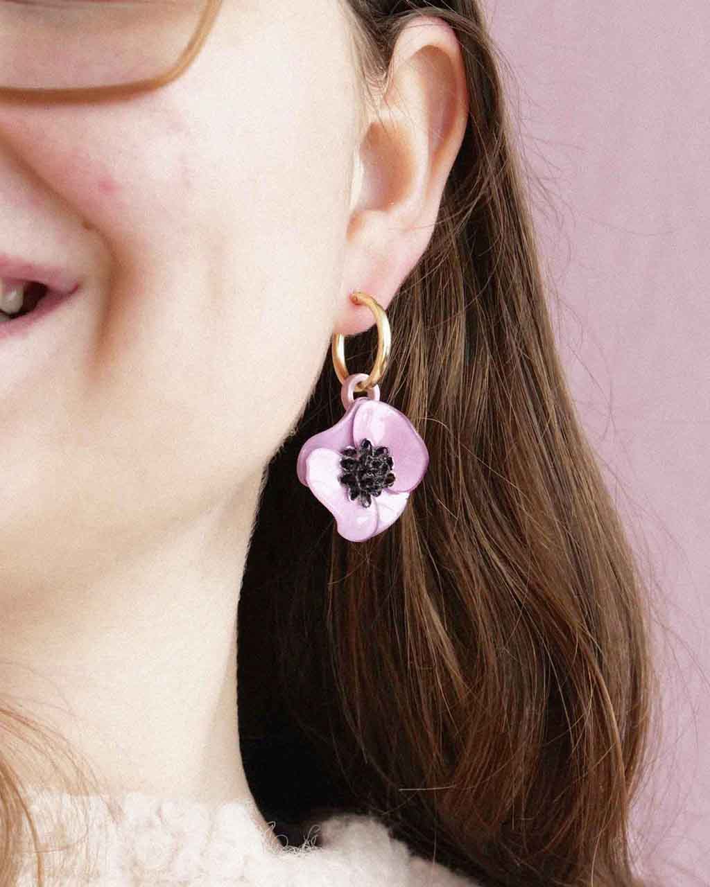 Boules d'oreilles violettes portées sur une oreille all-groups