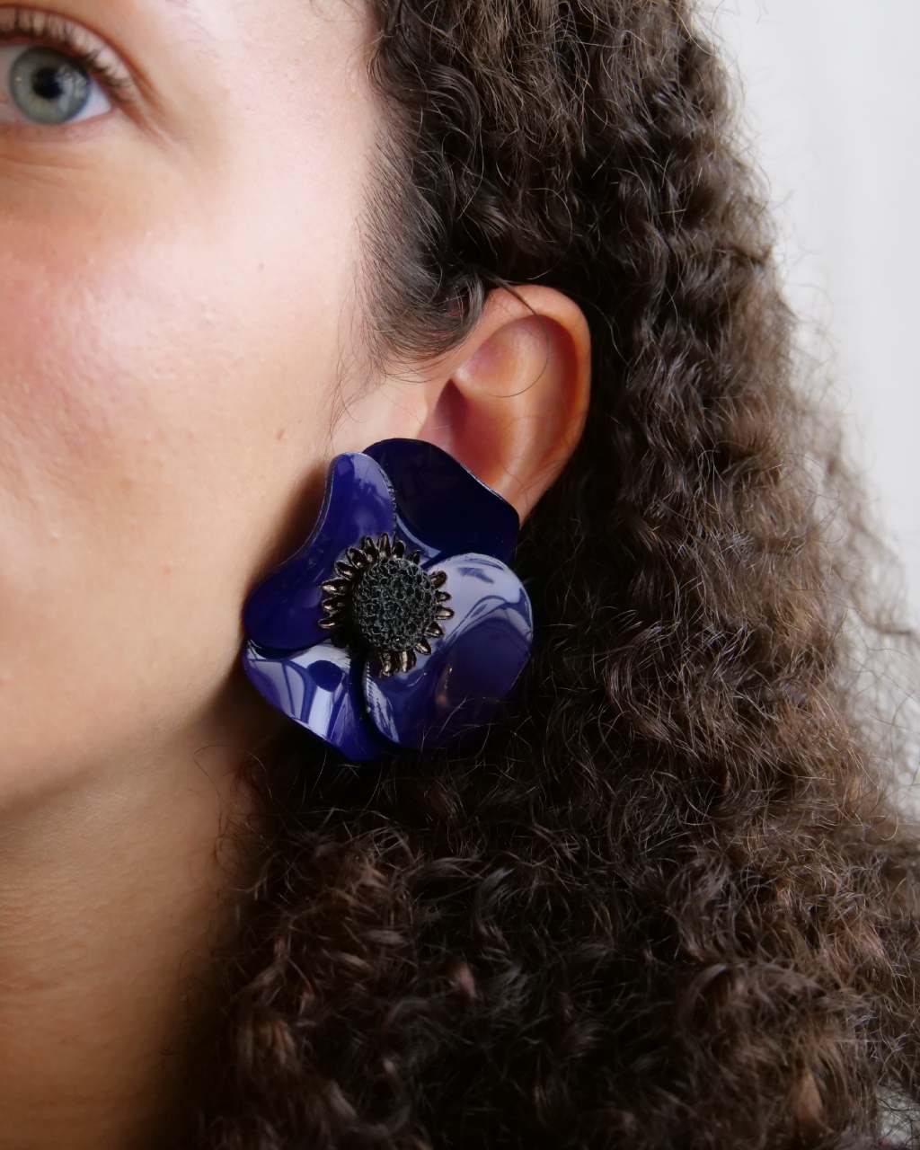 all-groups femme portant des boucles d'oreilles bleues