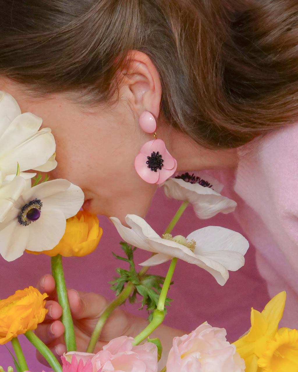 all-groups Femme penchée portant une boucle d'oreille fantaisie longue rose pale