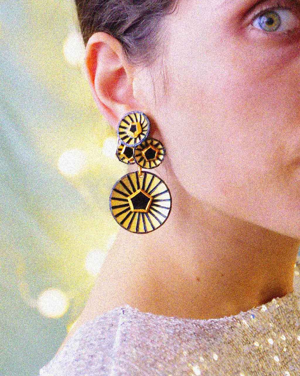 Femme portant une boucle d'oreille femme pendante en or all-groups