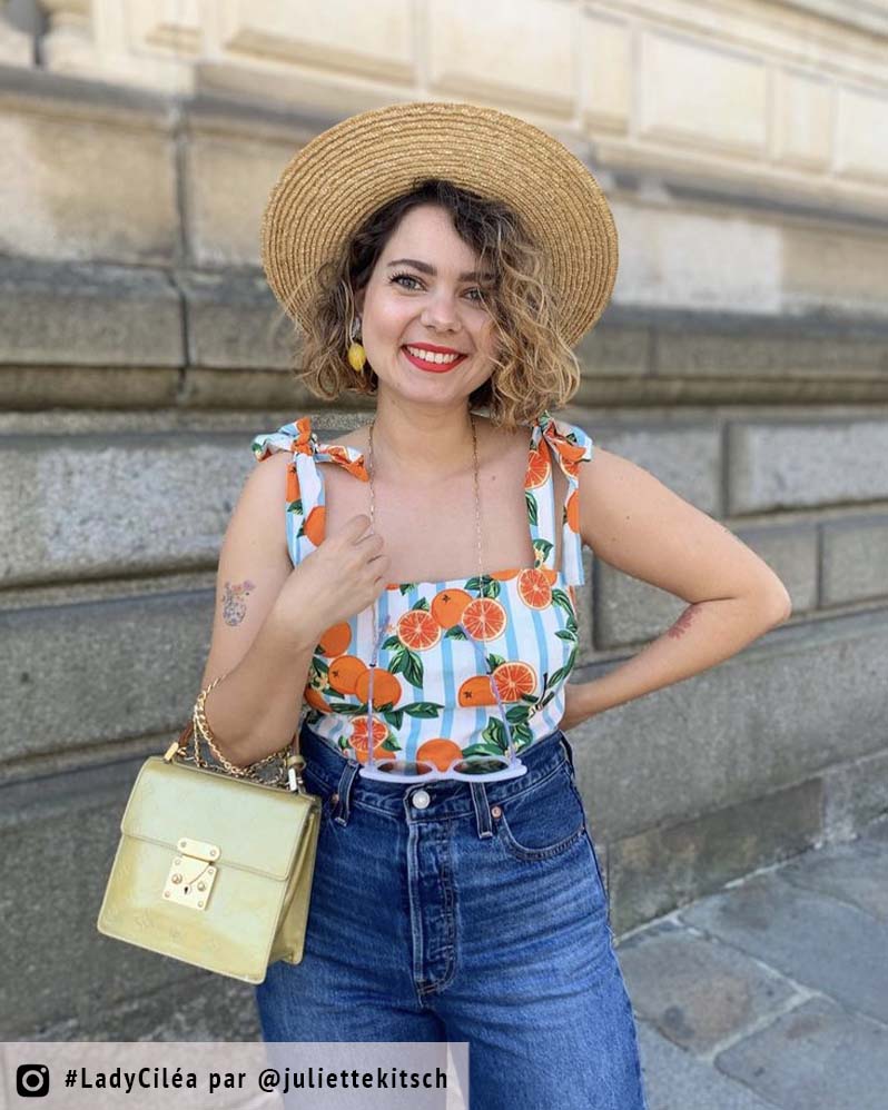 femme au chapeau avec des boucles d'oreilles citron