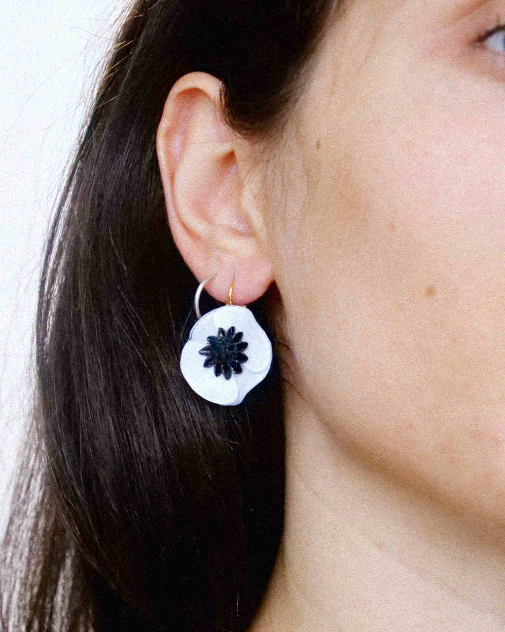 Femme portant des boucles d'oreilles fleurs blanches