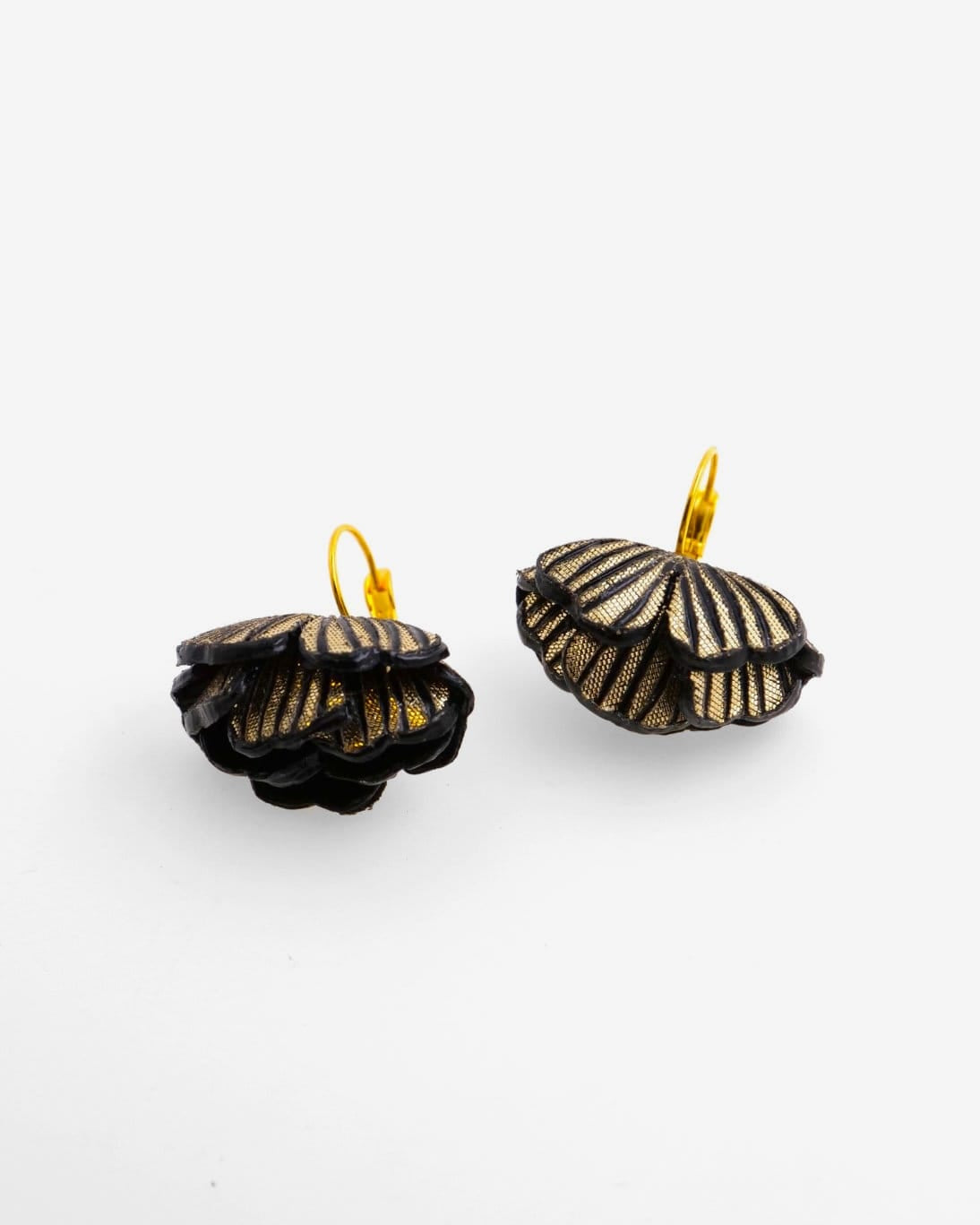Petites boucles d'oreilles originales avec un effet lumineux unique qui apporte un contraste à la couleur sombre des boucles.