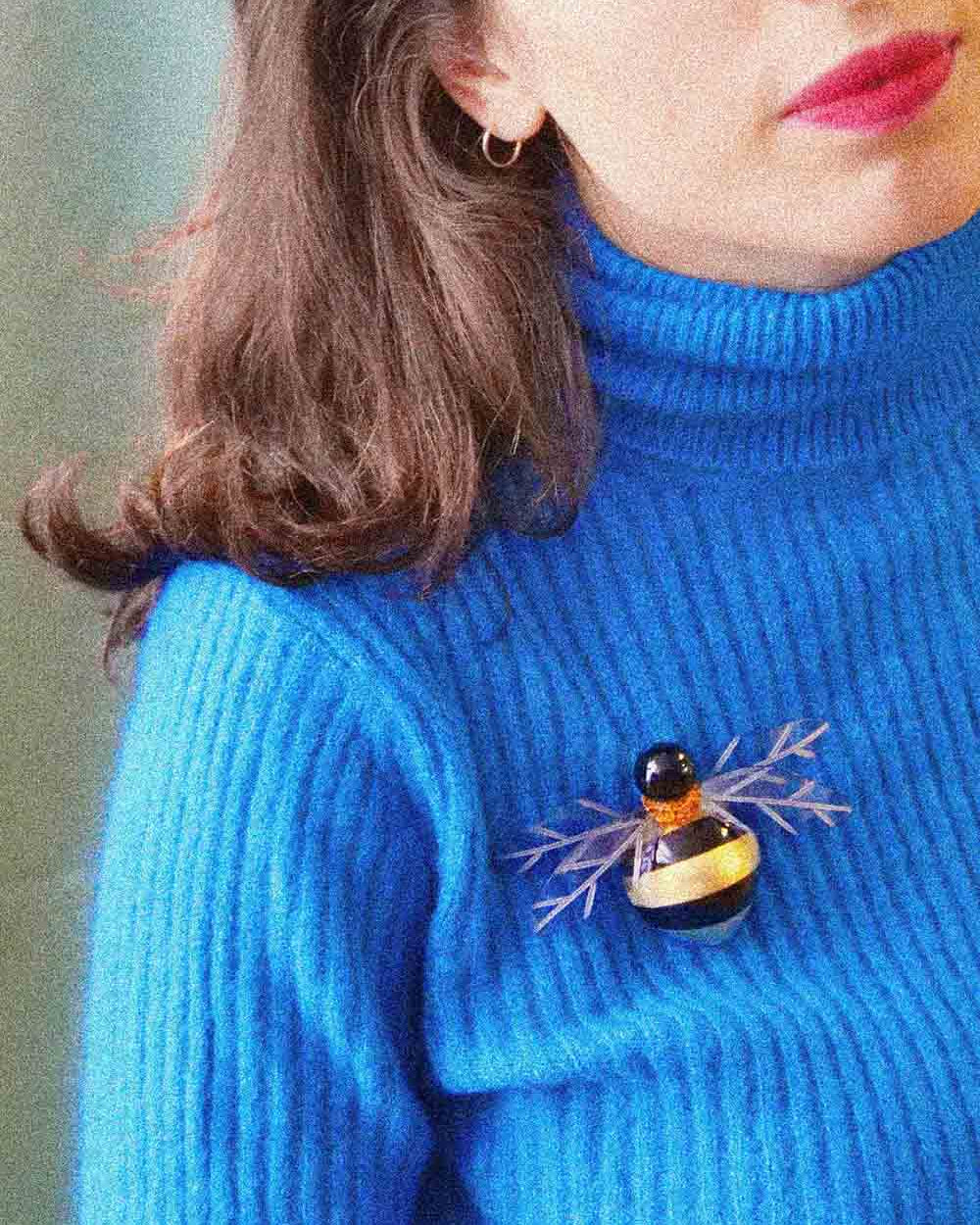 Femme portant une broche abeille dorée