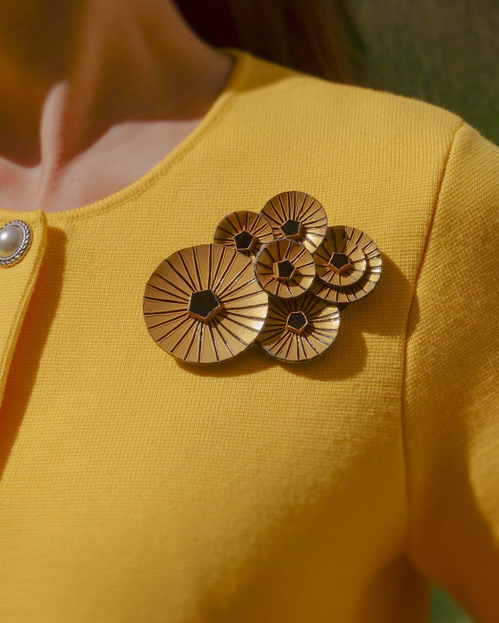 Broche bijou moderne portée sur un haut jaune