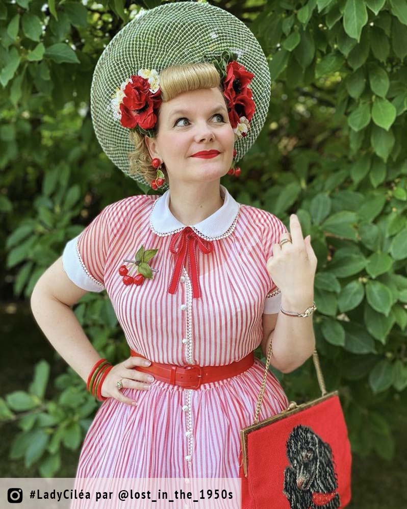 femme devant fond vert portant une robe et des accessoires rouges
