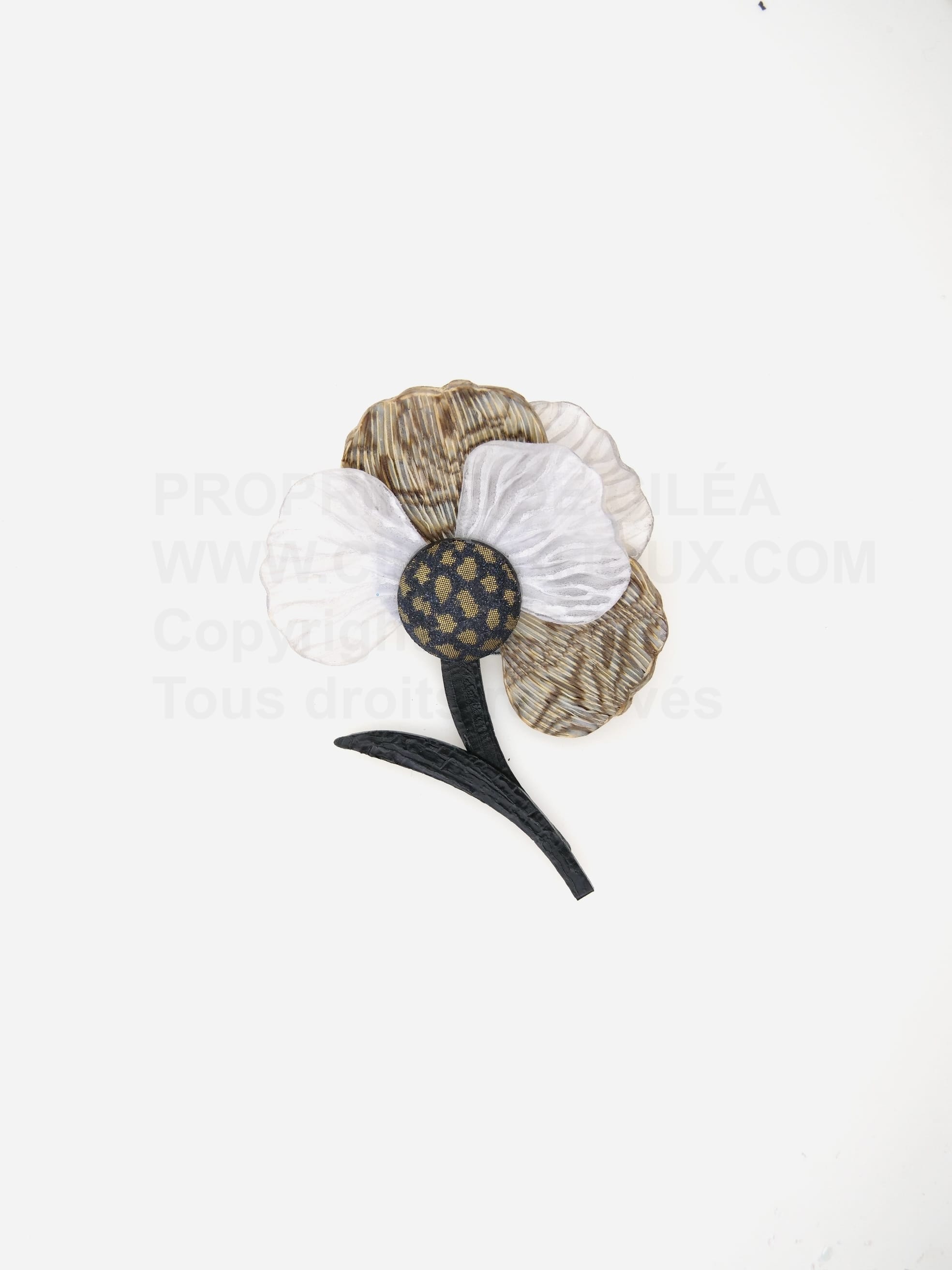 Cette broche fleurie Calypso est accompagnée d'une tige noir et de 5 pétales en ivoire et gris.