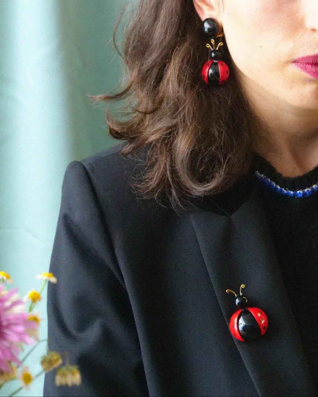 Femme portant une broche bijou fantaisie coccinelle