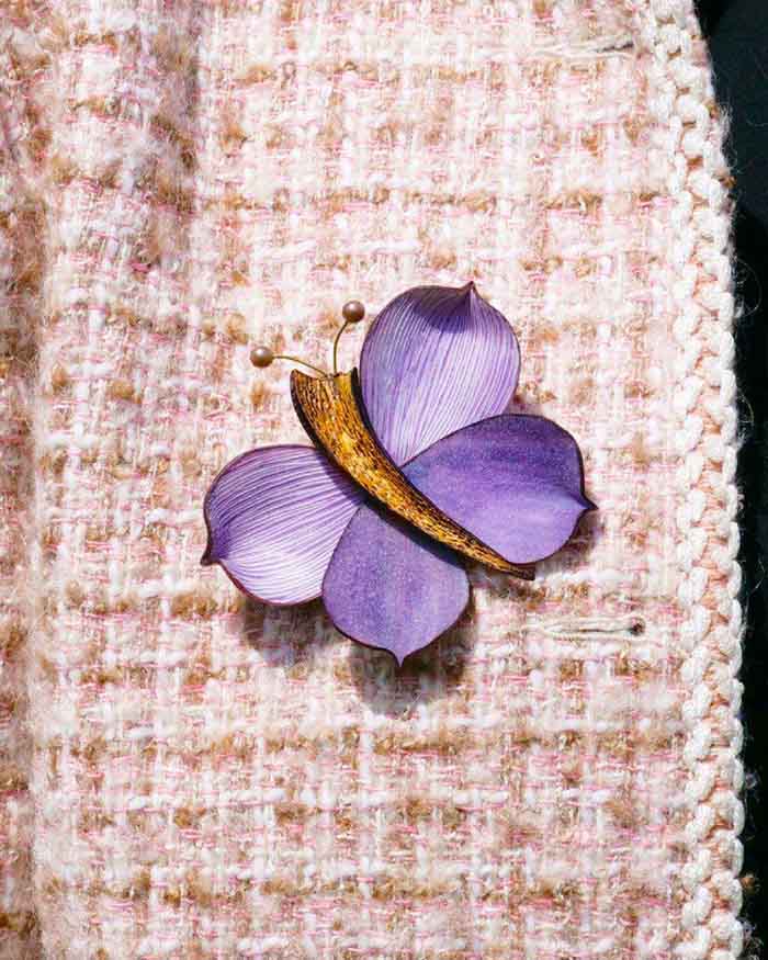 all-groups Broche papillon violette sur une veste en tweed