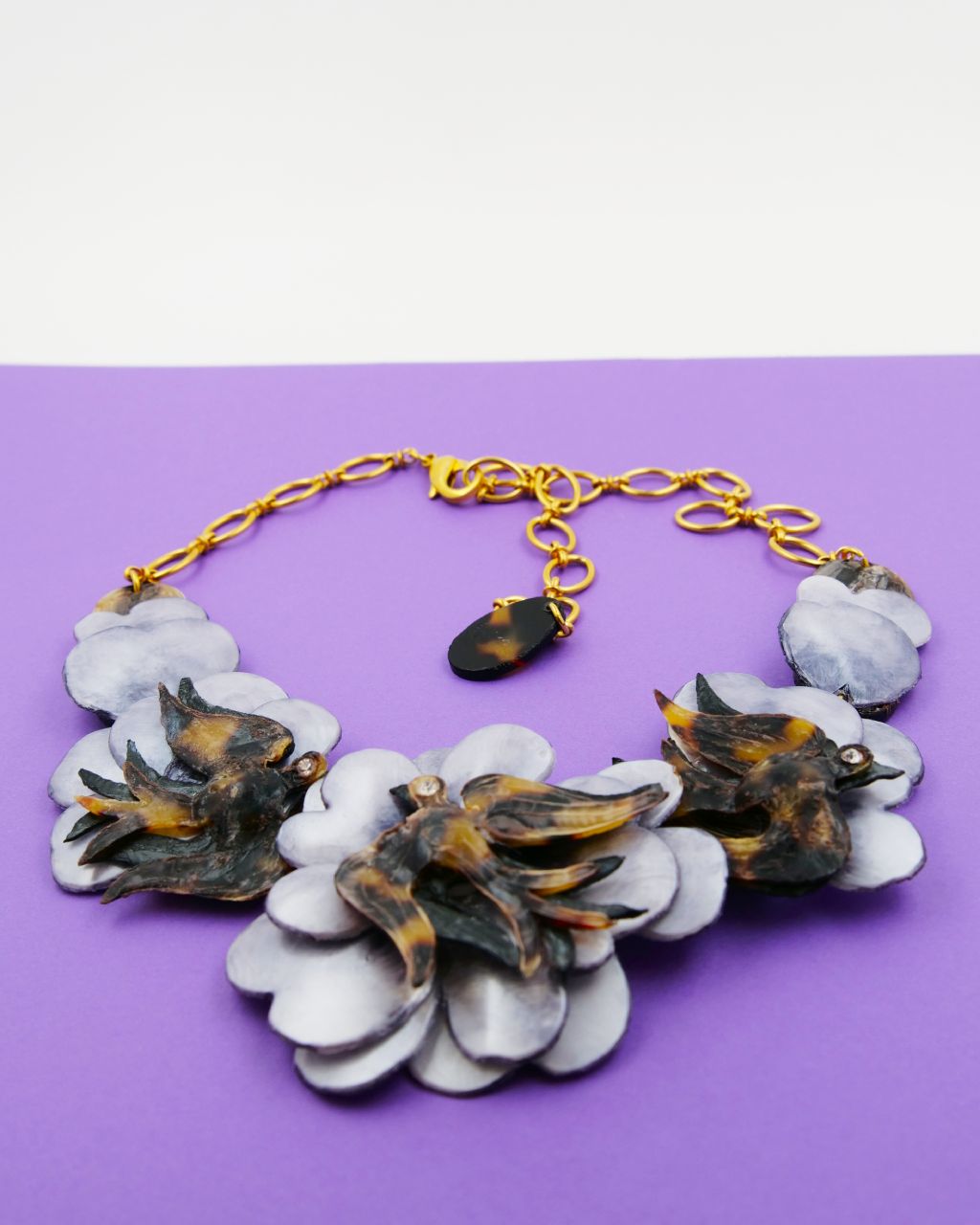 all-groups collier cabourg avec sa chaine dorée sur fond violet