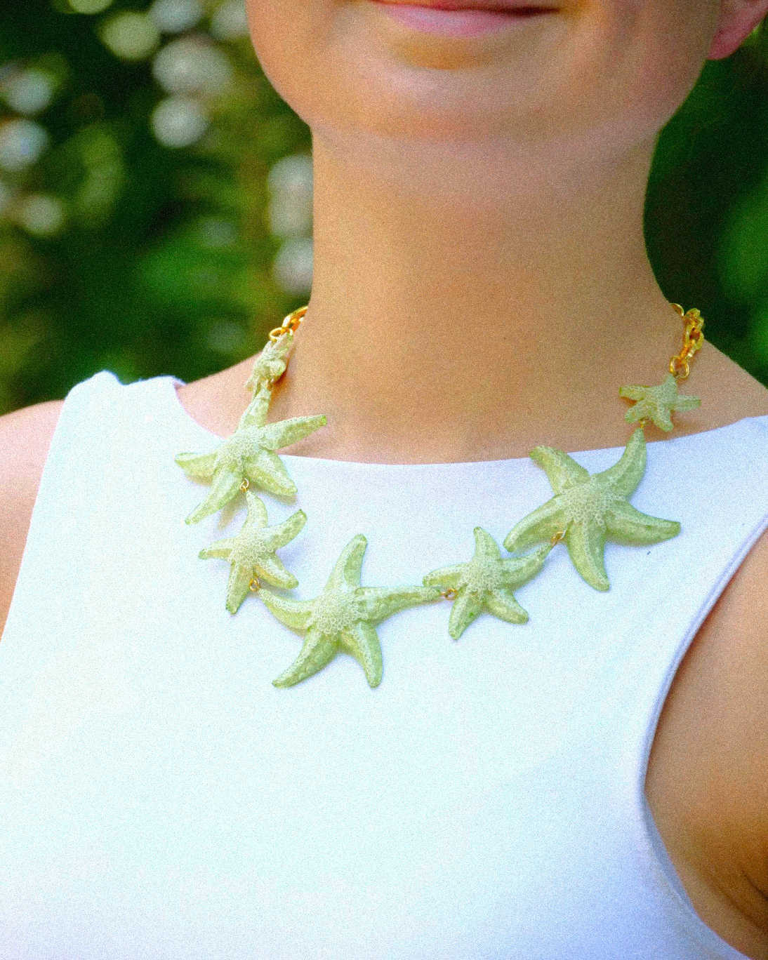 Femme portant un collier étoile de mer vert all-groups