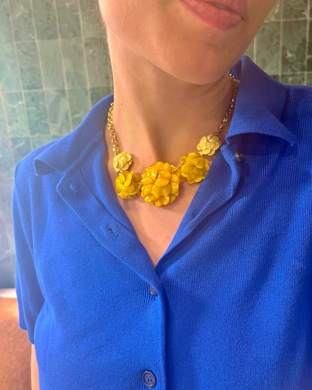 Joli collier fantaisie original femme jaune pétant porté par une jeune femme qui l'associe avec un haut bleu électrique