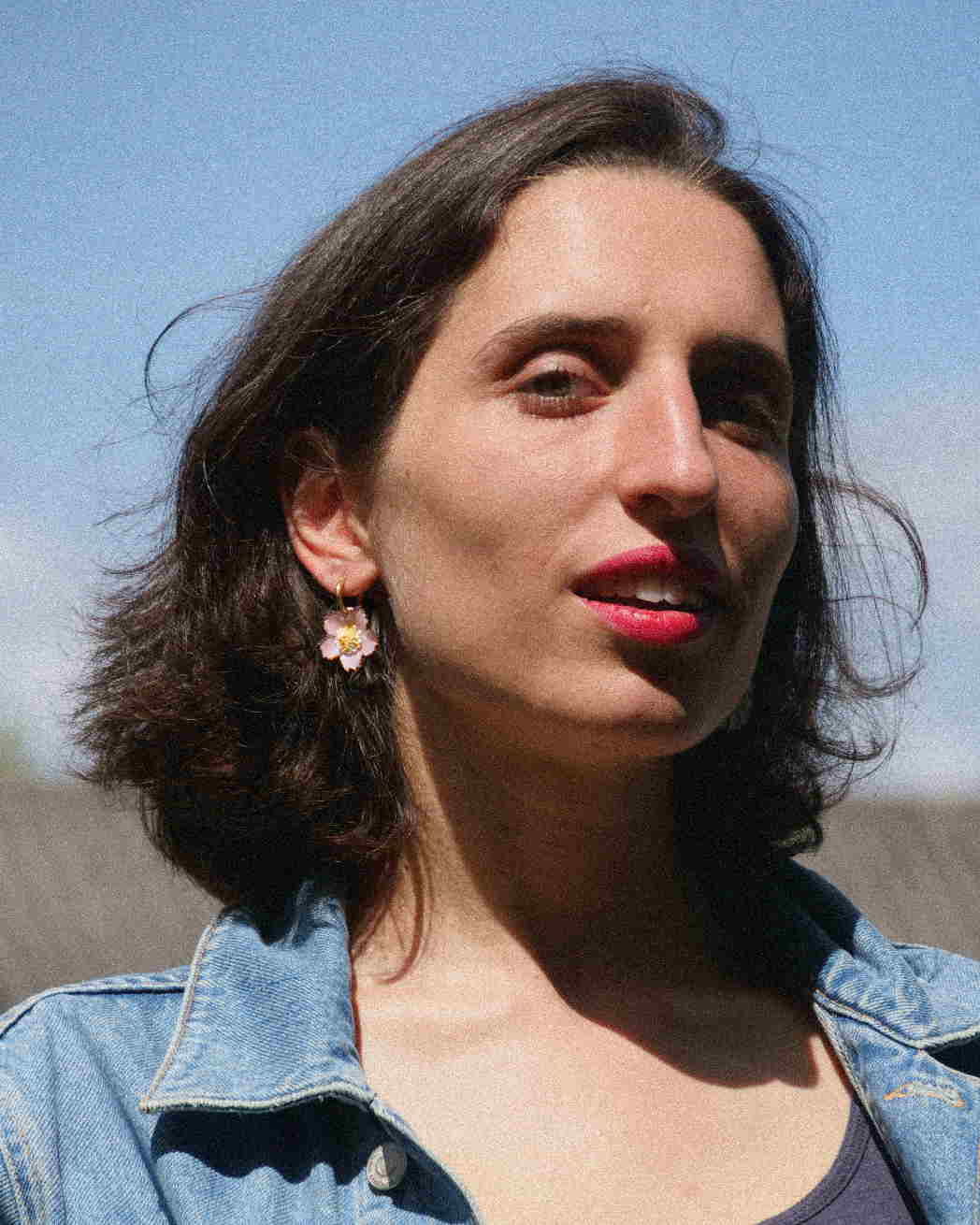 Femme portant des boucles d'oreilles créoles roses