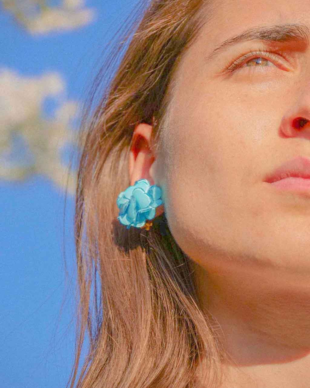 Bijoux d'oreilles fleuris bleus portés all-groups