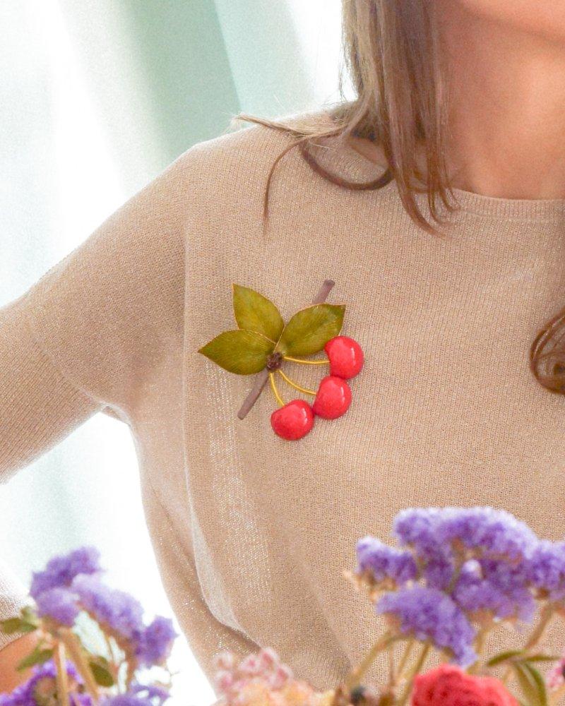 Femme portant une broche femme fantaisie en forme de cerises rouges