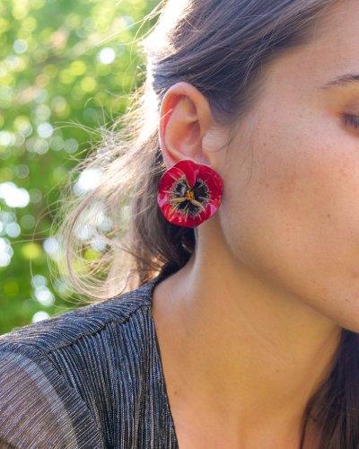 all-groups Femme portant des boucles d'oreilles colorées rouges