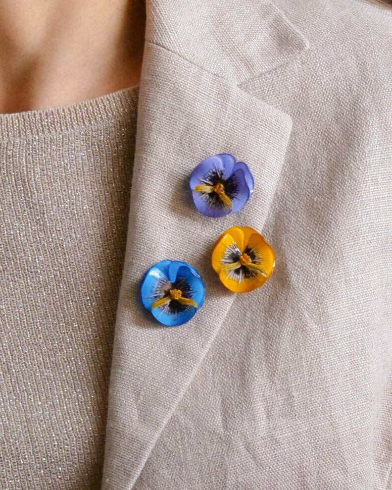 all-groups Trois pin's fleurs colorés sur une veste en lin beige