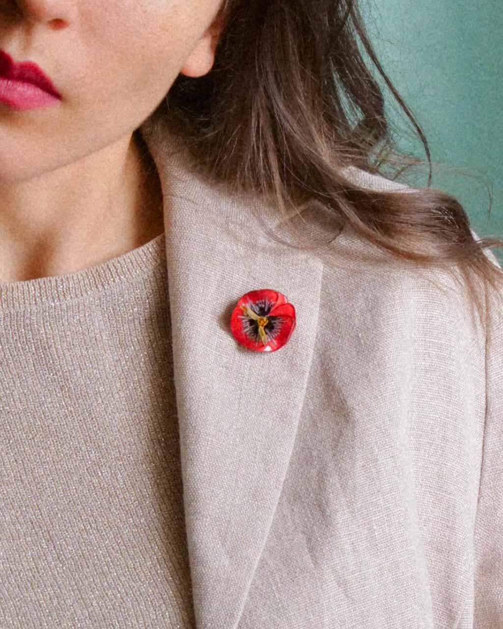 all-groups Petit pin's fleur rouge porté sur une veste