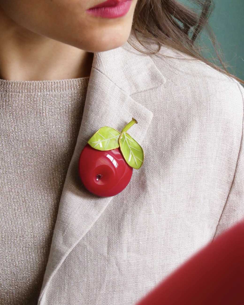 Femme portant une broche accessoire pomme rouge