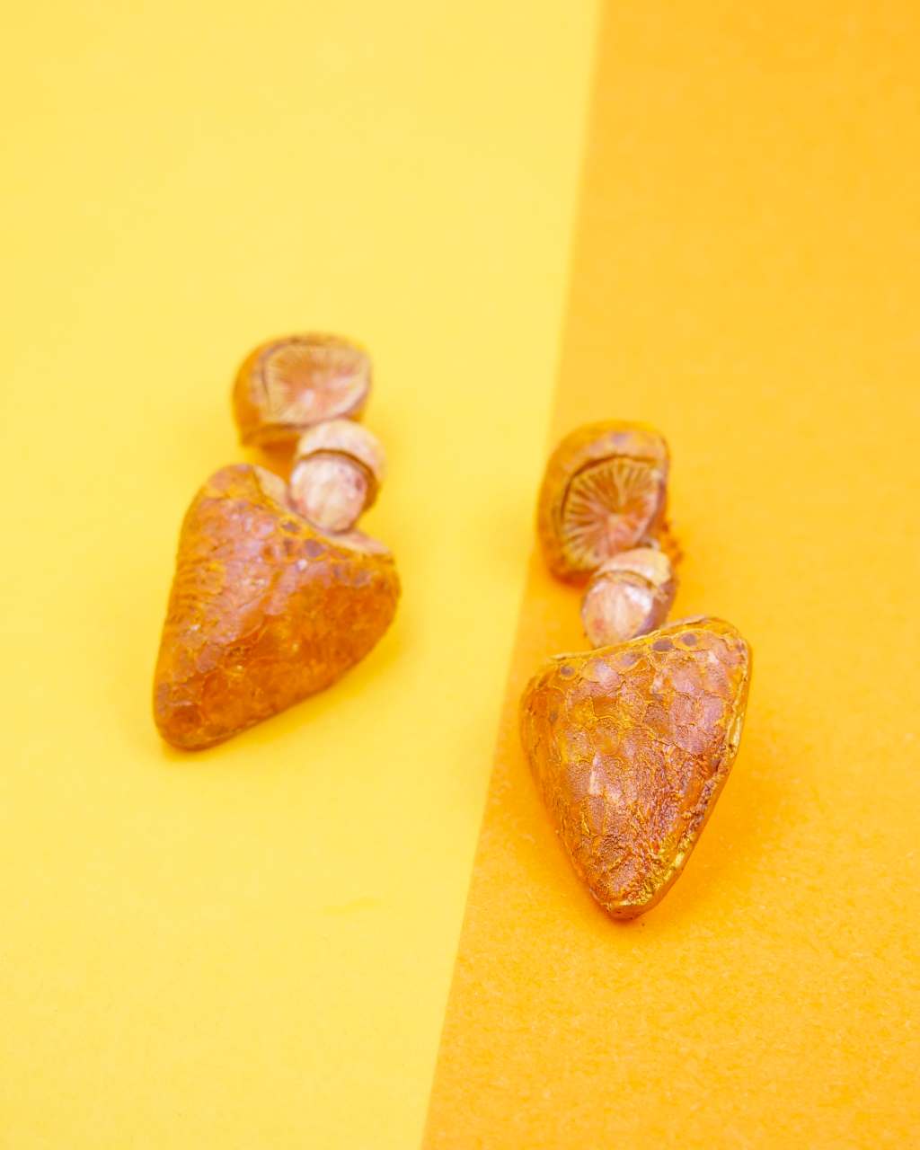 all-groups boucles d'oreilles Simon sur fond orange et jaune, elles représentent des champignons