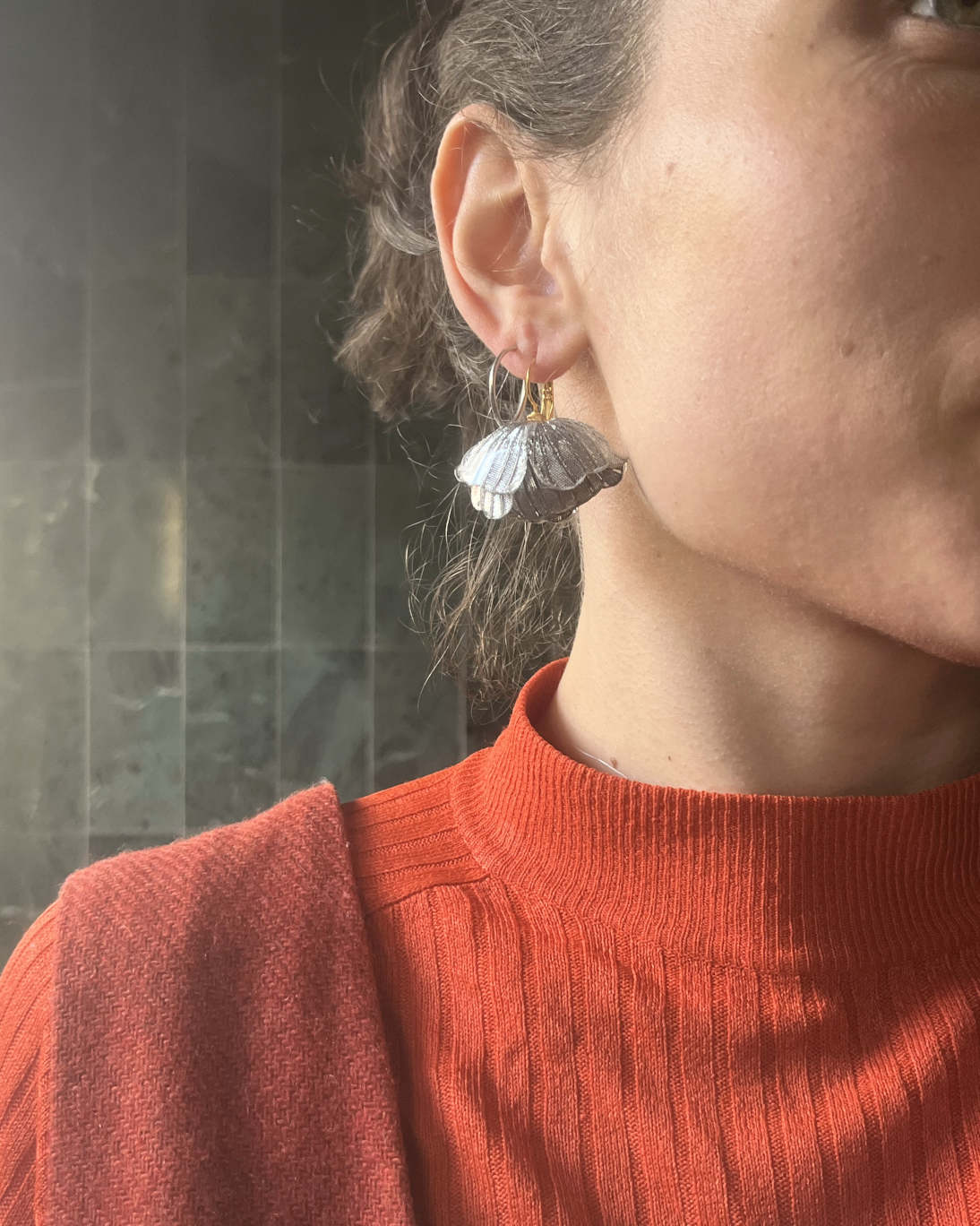 all-groups ces boucles d'oreilles originales argentées signées Ciléa Paris sont portées par une jeune femme avec un haut coloré rouge.