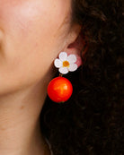 all-groups boucles oreilles orange qui sont portées par une jeune femme élégante