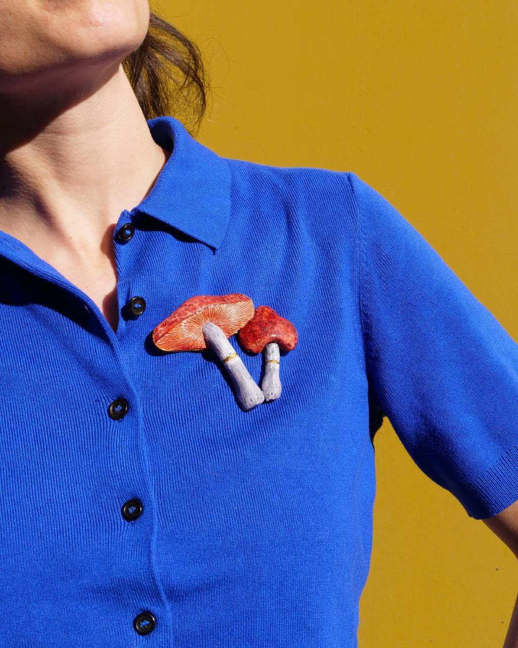 all-groups broche artisanale rouge champignon simon sur un haut bleu porte par une femme