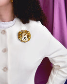 La broche Barnum, parmi nos bijoux lion, est portée sur un pull blanc par une femme.