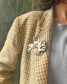 all-groups femme portant une broche oiseaux sur une veste