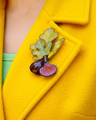 all-groups jolie broche figue sur un manteau coloré jaune
