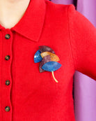 all-groups broche originale Ebisu, sur un pull très coloré pour femme 