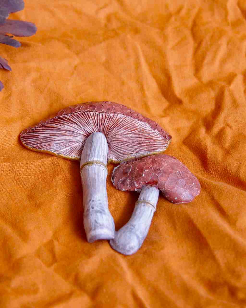 all-groups la broche simon est une creation artisanale qui représente un champignon sur fond orange