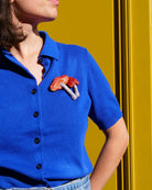 all-groups broche champignon simon portee par une femme avec un haut bleu