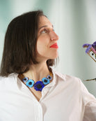 Femme portant un petit collier artisanal femme avec 5 fleurs bleues