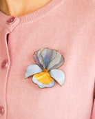 all-groups fleurs broche portée par une jeune femme tendance