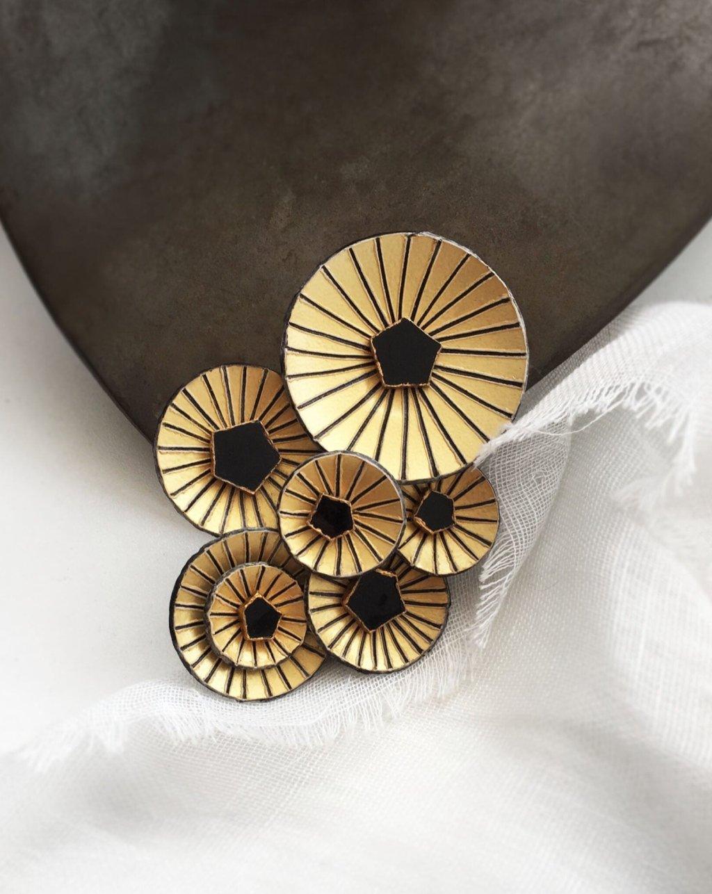 Broche bijou graphique de couleur dorée et noire