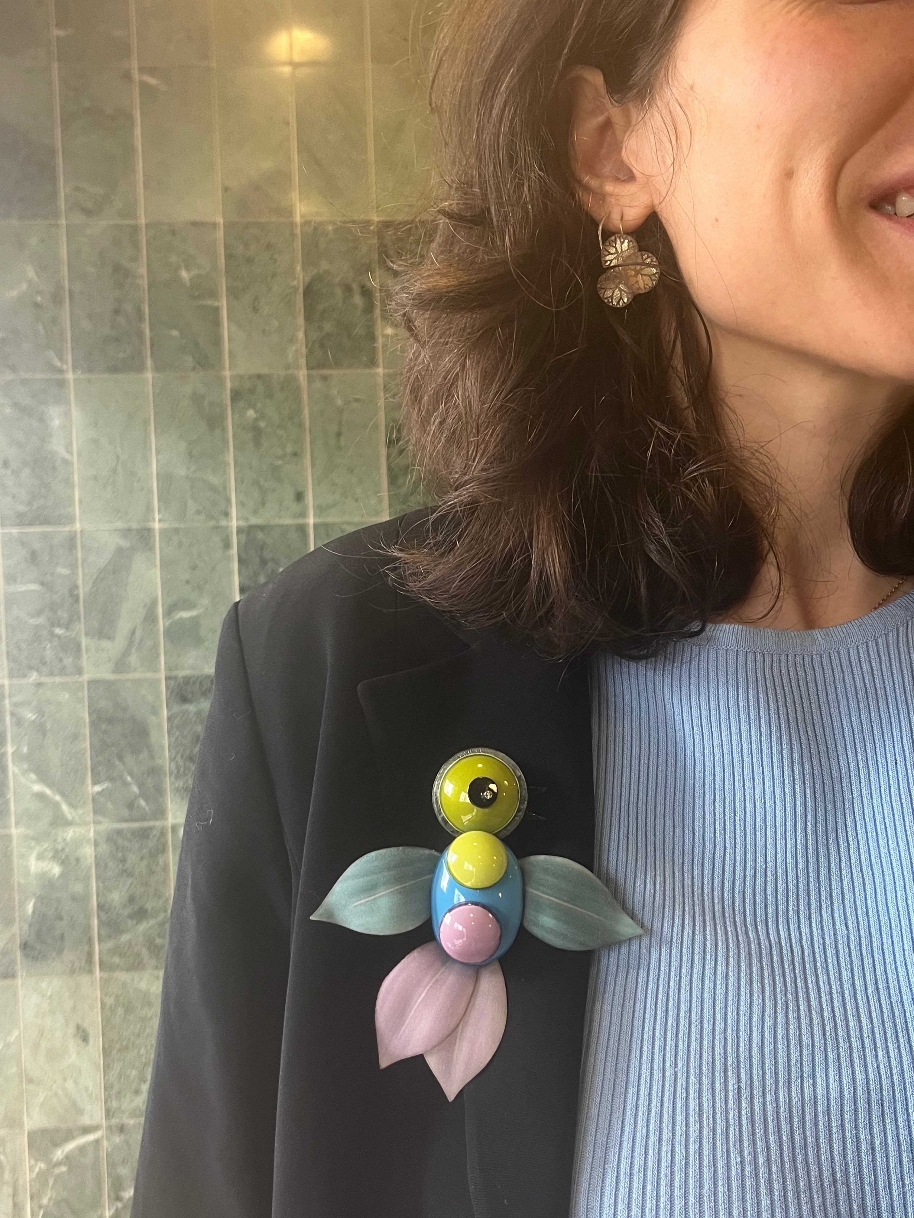 Femme portant une broche originale colibri sur son blazer all-groups